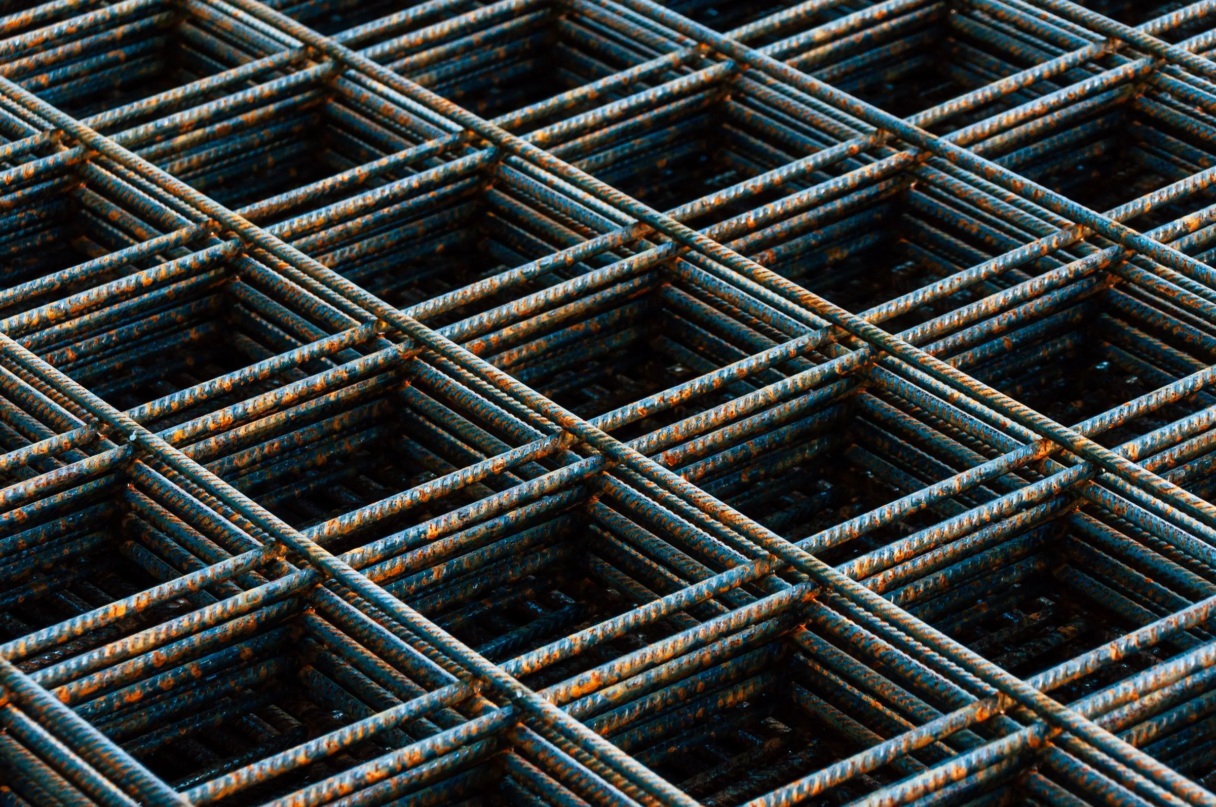 Close-up of a grid of rusted steel reinforcing bars tied together at their intersections